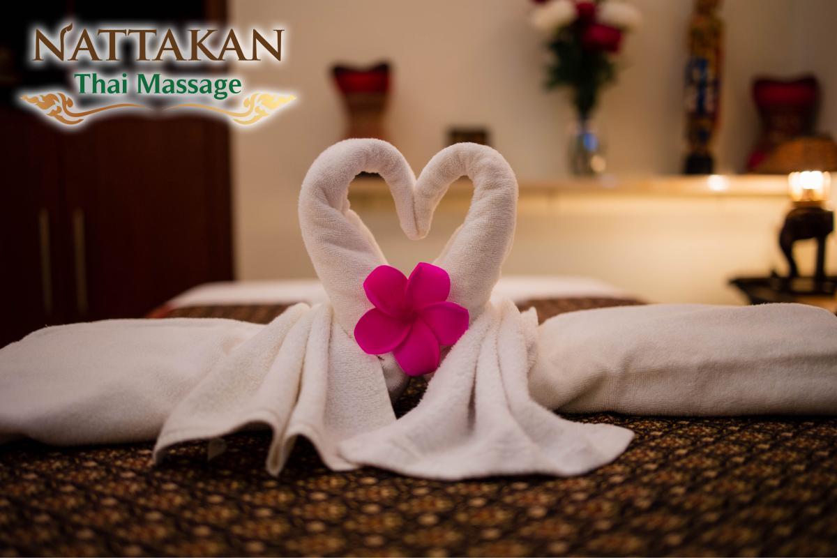 Decorative swan towel with a pink flower in a relaxing massage room at Nattakan Thai Massage.