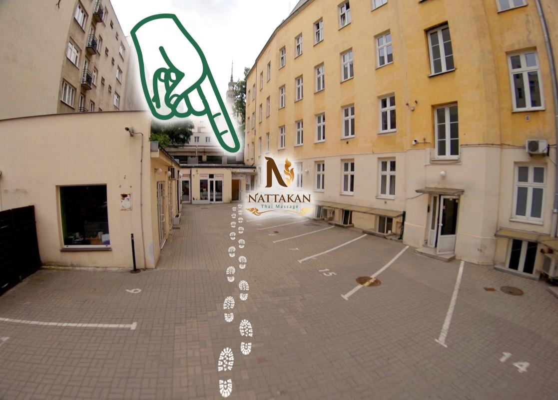 Entrance to Nattakan Thai Massage with a guiding path of footprints in a courtyard, surrounded by beige and yellow buildings. A large green hand graphic points towards the entrance, highlighting the Nattakan Thai Massage logo.